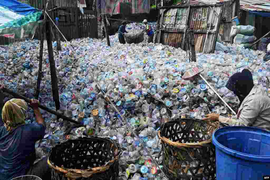 Workers collect plastic bottles at a dump site in Banda Aceh, Indonesia.