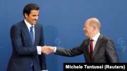 Emir Qatar Sheikh Tamim bin Hamad al-Thani dan Kanselir Jerman Olaf Scholz berjabat tangan saat mereka menghadiri konferensi pers di Kanselir, di Berlin, Jerman, 20 Mei 2022. (Foto: REUTERS/Michele Tantussi)