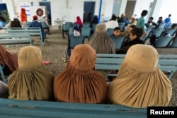 FILE - Afghan women who are living in Pakistan wait to get registered during a proof of registration drive at United Nations High Commissioner for Refugees (UNHCR) office in Peshawar, Pakistan, Sept. 30, 2021.