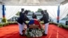 Los guardias de honor presidenciales colocan una bandera nacional sobre el ataúd del difunto presidente haitiano Jovenel Moise, quien fue asesinado a tiros, durante el funeral en la casa de su familia en Cabo Haitiano, Haití, el 23 de julio de 2021.