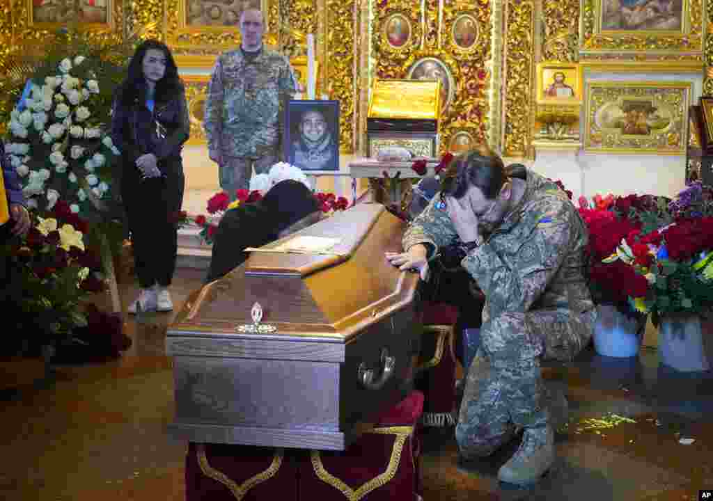 A soldier pays his last tribute to volunteer soldier Oleksandr Makhov, 36, a well-known Ukrainian journalist killed by Russian troops, during his funeral at St Michael cathedral in Kyiv, Ukraine.