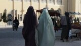 Burqa-clad women walk along a street in Kandahar, Afghanistan, on May 7, 2022.