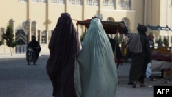 Burqa-clad women walk along a street in Kandahar, Afghanistan, on May 7, 2022.