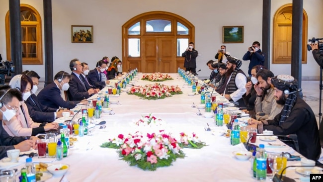 FILE - This handout photo released by the Taliban Foreign Ministry shows Taliban Foreign Minister Amir Khan Muttaqi, center-right, meeting with China's Foreign Minister Wang Yi, center-left, in Kabul on March 24, 2022