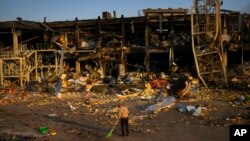 A man sweeps rubble next to a shopping and entertainment mall destroyed after a Russian missiles strike on May 9, in Odesa, Ukraine, May 13, 2022. 