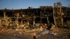 A man sweeps rubble next to a shopping and entertainment mall destroyed after a Russian missiles strike on May 9, in Odesa, Ukraine, May 13, 2022. 