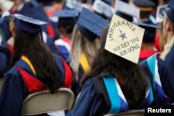 A graduate wears a mortar board adorned with a message in support of immigrants before the start of commencement exercises at Liberty University in Lynchburg, Virginia, May 11, 2019.