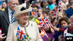 Ratu Elizabeth II dari Inggris disambut oleh para simpatisan yang mengibarkan bendera saat ia mengunjungi City Varieties Music Hall di Leeds, West Yorkshire, Inggris utara. (Foto: AFP)