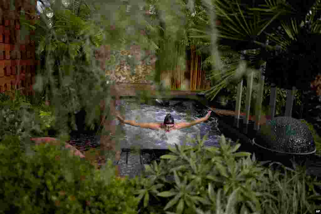 Gold medal winning British Paralympic swimmer Jessica-Jane Applegate poses for photographers by swimming butterfly in a swim spa which forms part of the &quot;Out Of The Shadows&quot; show garden during the Chelsea Flower Show in London.