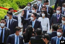 South Korean President Yoon Suk Yeol, center, and his wife Kim Keon-hee arrive to attend his inauguration in front of the National Assembly in Seoul, South Korea, Tuesday, May 10, 2022. (Jeon Heon-Kyun/Pool Photo via AP)