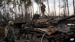 Un soldat ukrainien debout sur un tank russe aux environs de Kiev, le 31 mars 2022.