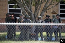 Petugas penegak hukum berdiri di luar Robb Elementary School setelah penembakan fatal pada 24 Mei 2022 di Uvalde, Texas. (Foto: AP)