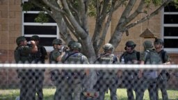 ARCHIVO - Agentes del orden están parados afuera de la Escuela Primaria Robb tras un tiroteo fatal el 24 de mayo del 2022 en Uvalde, Texas.
