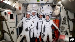 European Space Agency astronaut Matthias Maurer and NASA astronauts Tom Marshburn, Raja Chari and Kayla Barron pose for a photo in their spacesuits aboard the International Space Station's Harmony module on April 21, 2022. (NASA via AP)