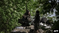 在乌克兰东部卢甘斯克州利西昌斯科市附近的前线，一名乌克兰军人在坦克上执行警戒任务。(2022年5月20日)