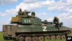 A crew of self-propelled artillery vehicles of the Donetsk People's Republic militia prepares to fire toward a Ukrainian army position, near the town of Yasynuvataya, outside Donetsk, in territory under the government of the Donetsk People's Republic, eastern Ukraine, May 20, 2022.