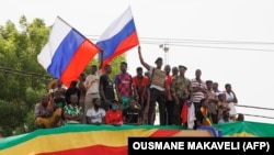 Des Maliens agitent des drapeaux de la Russie lors d'une manifestation pro-Junte à Bamako, le 13 mai 2022. 