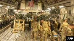 FILE - This handout photo courtesy of the U.S. Marine Corps obtained on April 27, 2022, shows U.S. Marines load an M777 towed 155 mm howitzer into the cargo hold of a U.S. Air Force C-17 Globemaster III at March Air Reserve Base, California, April 21, 2022.