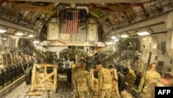 Морские пехотинцы США грузят 155-мм гаубицы М777 на борт грузового самолета ВВС США С-17 Globemaster. Калифорния, 21 апреля 2022.
