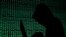 FILE - A hooded man holds a laptop computer as cybercode is projected on him in this photo illustration.