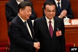 FILE - China's President Xi Jinping, left, shakes hands with former Premier Li Keqiang during the fourth plenary session of the National People's Congress at the Great Hall of the People in Beijing on March 11, 2023.