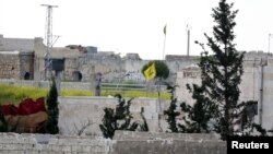 FILE - A Hezbollah flag flutters in a government-controlled area, as seen from the rebel-controlled area of Karm al-Tarab frontline, near Aleppo international airport, April 22, 2015. 