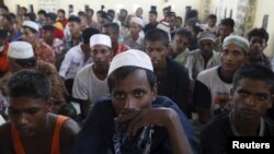 Sekelompok migran Rohingya dan Bangladesh duduk di tempat penampungan di Lhoksukon, NAD, Indonesia, 13 Mei 2015, setelah diselamatkan kapal-kapal nelayan Aceh karena kapal mereka nyaris tenggelam. (Roni Bintang/REUTERS) 