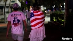 Beberapa mahasiswa berjalan-jalan di Pantai Miami setelah otoritas menutup restoran, bar, bioskop, gym dan bisnis serupa untuk pencegahan virus corona, Miami Beach, Florida, 18 Maret 2020. (Foto: Reuters)