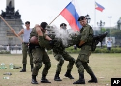 A Russian Marine uses a hammer to break a brick on top of his comrade's stomach during a Capability Demonstration at Manila's Rizal Park, Philippines, Jan. 5, 2017.