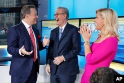 Fox News Chief National Correspondent Ed Henry, left, is welcomed by co-hosts Steve Doocy and Ainsley Earhardt on the "Fox &amp; Friends" television program in New York, Sept. 6, 2019.