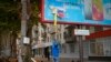 Lokalni stanovnik uklanja rusku zastavu s reklamnog panoa u  Hersonu, Ukrajina, nedjelja, 13. studenog 2022.