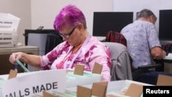 Staff work to 'cure' ballots, the process of contacting the voter to allow them to amend or correct issues with their ballot, for the midterm elections at the Maricopa County Tabulation and Election Center in Phoenix, Arizona, Nov. 13, 2022. 