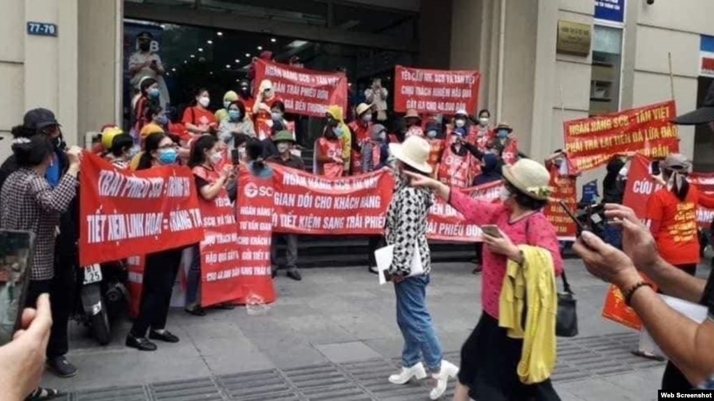 Người dân căng biểu ngữ đòi trả lại tiền mua trái phiếu trước chi nhánh ngân hàng SCB ở Hà Nội