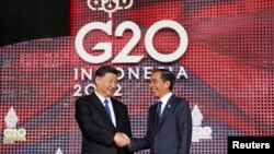 Presiden China Xi Jinping bersalaman dengan Presiden Joko Widodo ketika ia tiba untuk menghadiri KTT G20 di Nusa Dua, Bali, pada 15 November 2022. (Foto: Reuters/Kevin Lamarque)