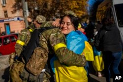 A Kherson resident hugs a Ukrainian defense force member in Kherson, southern Ukraine, Nov. 14, 2022.