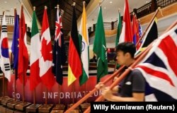 Seorang staf menyiapkan bendera jelang KTT G20 di Nusa Dua, Bali, 12 November 2022. (Foto: REUTERS/Willy Kurniawan)