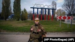 Українська військова біля знаку міста Херсон, 11 листопада 2022 року (AP Photo/Dagaz)