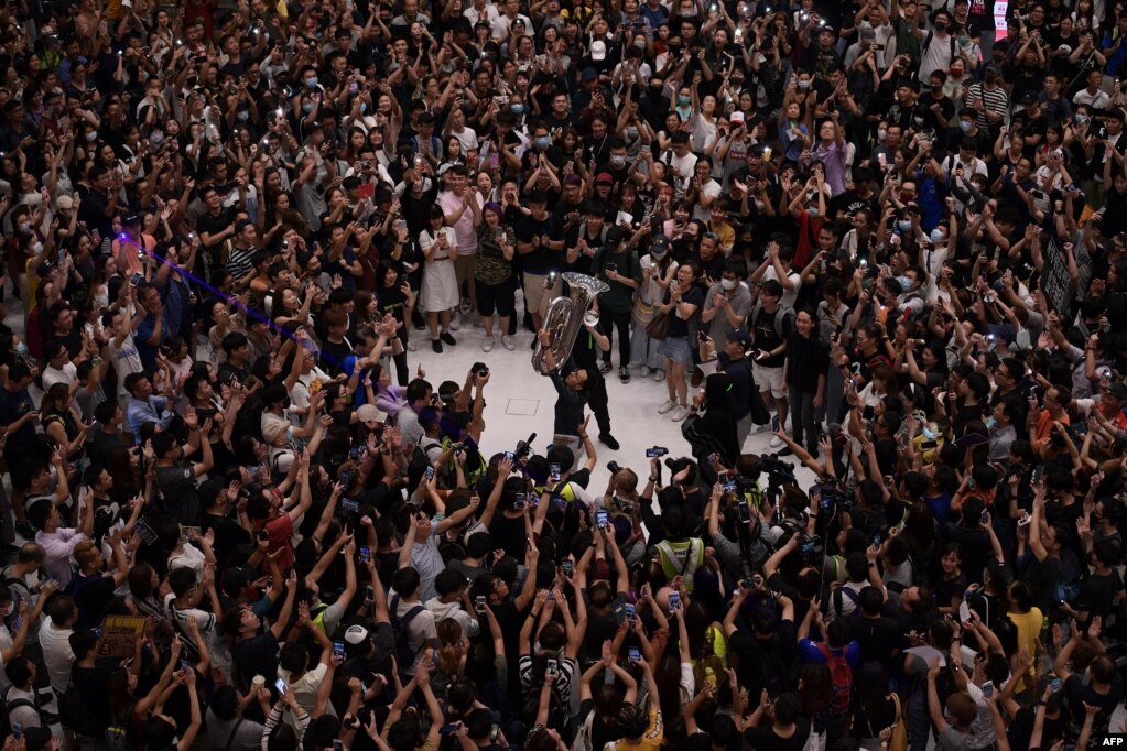 资料照：香港民众在一处商场内跟着演奏者合唱“GLORY TO HONG KONG”，即反修例歌曲《愿荣光归香港》的英文歌曲。（2019年9月11日）(photo:VOA)