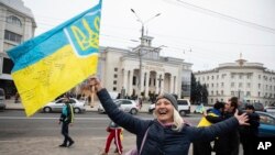 Para warga Ukraina berkumpul di pusat Kota Kherson pada 12 November 2022, untuk merayakan keberhasilan pasukan Ukraina merebut kembali kota tersebut dari genggaman Rusia. (Foto: AP/Yevhenii Zavhorodnii)