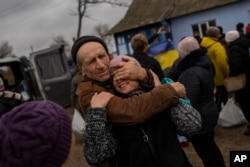 In the village of Tsentralne, Ukrainian family members are reunited for the first time since Russian troops withdrew from the Kherson region, southern Ukraine, Sunday, Nov. 13, 2022. (AP Photo/Bernat Armangue)