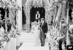 FILE - The former Tricia Nixon and her husband Edward Finch Cox, walk from the altar at the White House Rose Garden after their marriage, June 12, 1971.