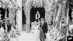 FILE - The former Tricia Nixon and her husband Edward Finch Cox, walk from the altar at the White House Rose Garden after their marriage, June 12, 1971.