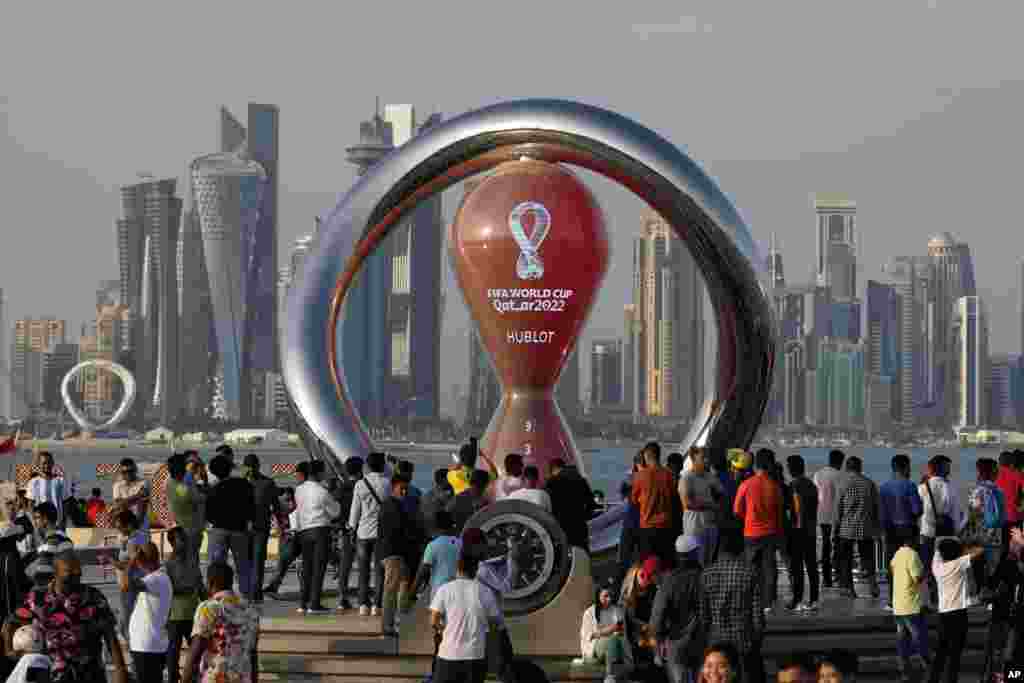 Orang-orang berkumpul di sekitar jam hitung mundur resmi yang menunjukkan sisa waktu hingga kick-off Piala Dunia 2022, di Doha, Qatar. Persiapan akhir sedang dilakukan untuk Piala Dunia sepak bola, yang dimulai pada 20 November saat timnas Qatar menghadapi Ekuador.(Foto: AP)&nbsp;