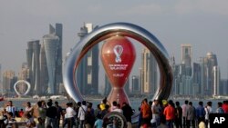 FILE: People gather around the official countdown clock showing remaining time until the kick-off of the World Cup 2022, in Doha, Qatar. Final preparations are being made for the soccer World Cup, which starts on Nov. 20 when Qatar faces Ecuador.