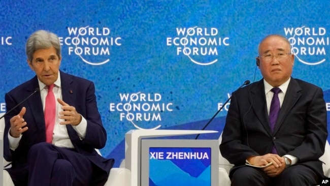 FILE - John Kerry, special U.S. presidential envoy for climate, gestures beside Xie Zhenhua, special Chinese envoy for climate change, during the World Economic Forum in Davos, Switzerland, May 24, 2022.