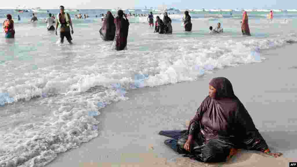A woman sits on Lido beach early in the morning in Mogadishu, Somalia.