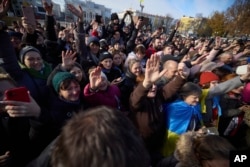 In this photo provided by the Ukrainian Presidential Press Office and posted on Facebook, local residents greet Ukrainian President Volodymyr Zelenskyy during his visit to Kherson, Ukraine, Monday, Nov. 14, 2022. (Ukrainian Presidential Press Office via AP)