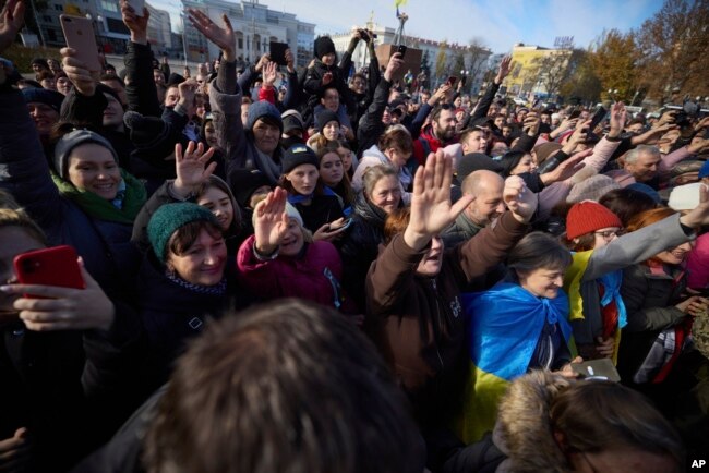 In this photo provided by the Ukrainian Presidential Press Office and posted on Facebook, local residents greet Ukrainian President Volodymyr Zelenskyy during his visit to Kherson, Ukraine, Monday, Nov. 14, 2022. (Ukrainian Presidential Press Office via AP)