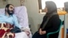 This handout picture provided by the Iranian Judiciary Media Centre reportedly shows Iranian blogger, human rights activist and political dissident Hossein Ronaghi lying on a hospital bed with his mother by his side in Tehran, on Nov. 14, 2022. 