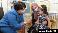  In this photo provided by the Children's Hospital of Eastern Ontario, Ayla Bashir and her mother, Sobia Qureshi, meet with Dr. Karen Fung Kee Fung, left, of the Ottawa Hospital in August 24, 2022. (André Coutu/CHEO via AP)